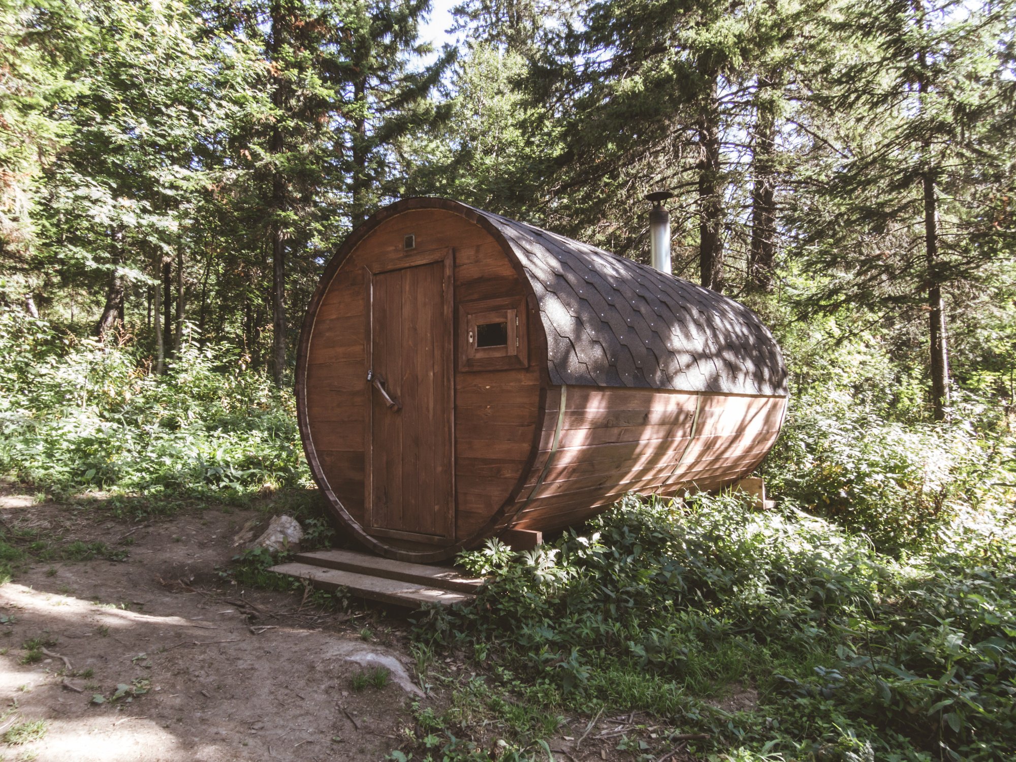 A personal sauna in the woods. Round wooden sauna in the forest. Barrel